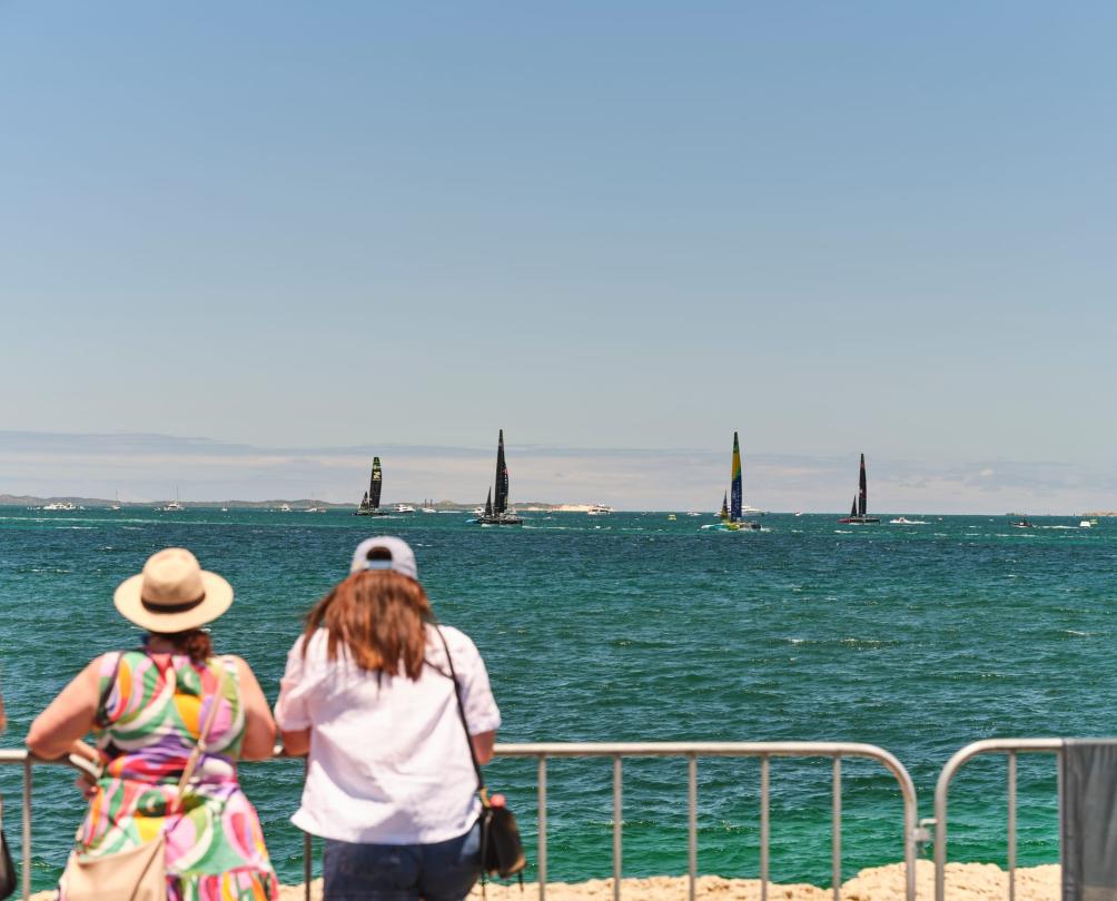two women looking out at sailboats in the ocean