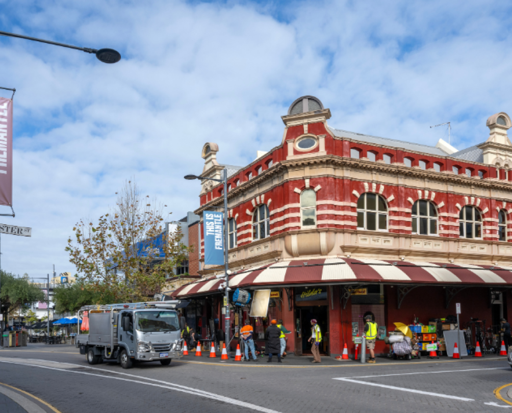 a street scape of an old building with a camera crew